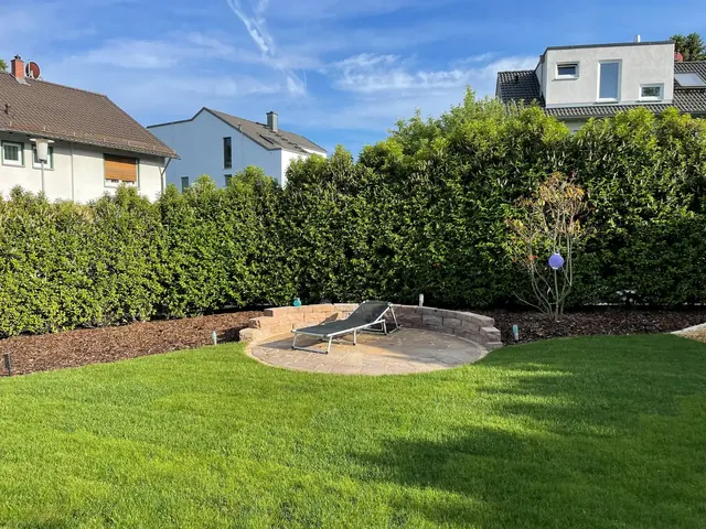 Rasenfläche mit Hecke und rundem Sitzplatz